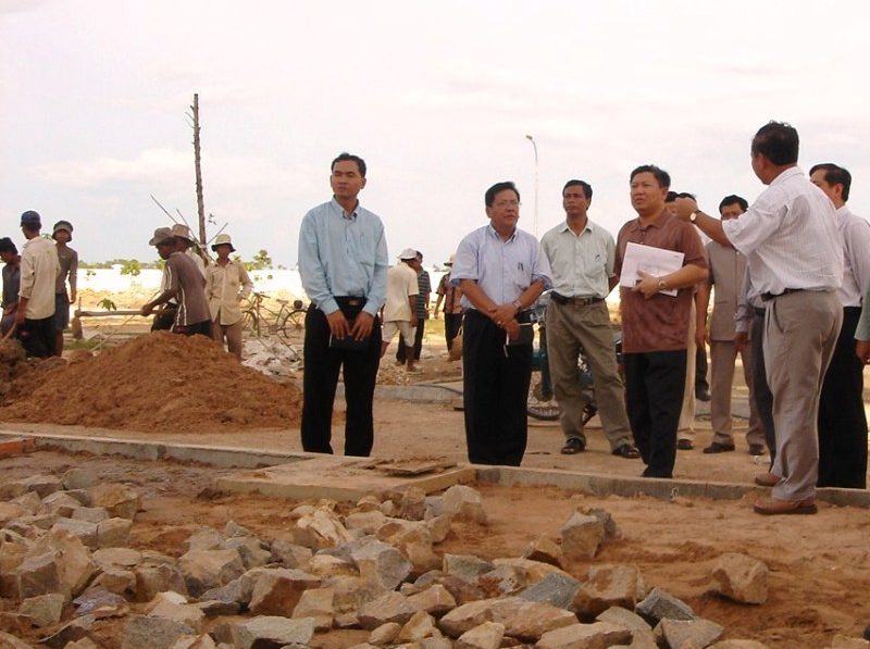 A group of officials stand on the future grounds of Svay Rieng University in 2004