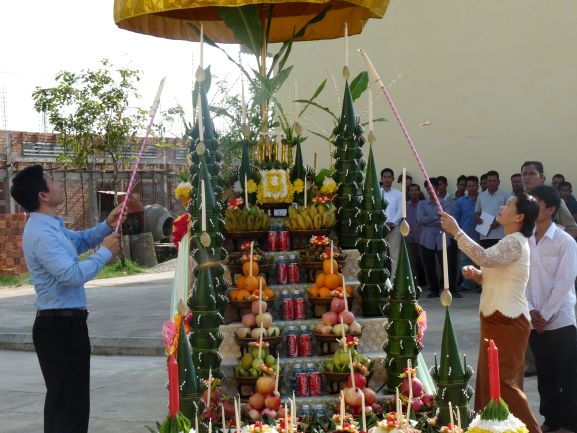 Staff light candles during a ceremony at Svay Rieng University